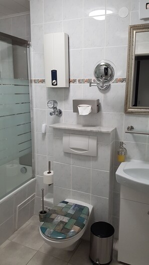 A bathroom with a toilet, bidet, sink, mirror, and a shower area. - App with air conditioning, pool, garage for car, bike, skis, AktivCard bayer.Wald optional (St. Englmar)