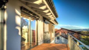 A modern house with a balcony, large windows, and a view of the countryside. - Apartment in an idyllic location and great views (Dormettingen)