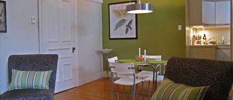 Une pièce comprenant une table à manger, des chaises, un canapé et un coin cuisine.