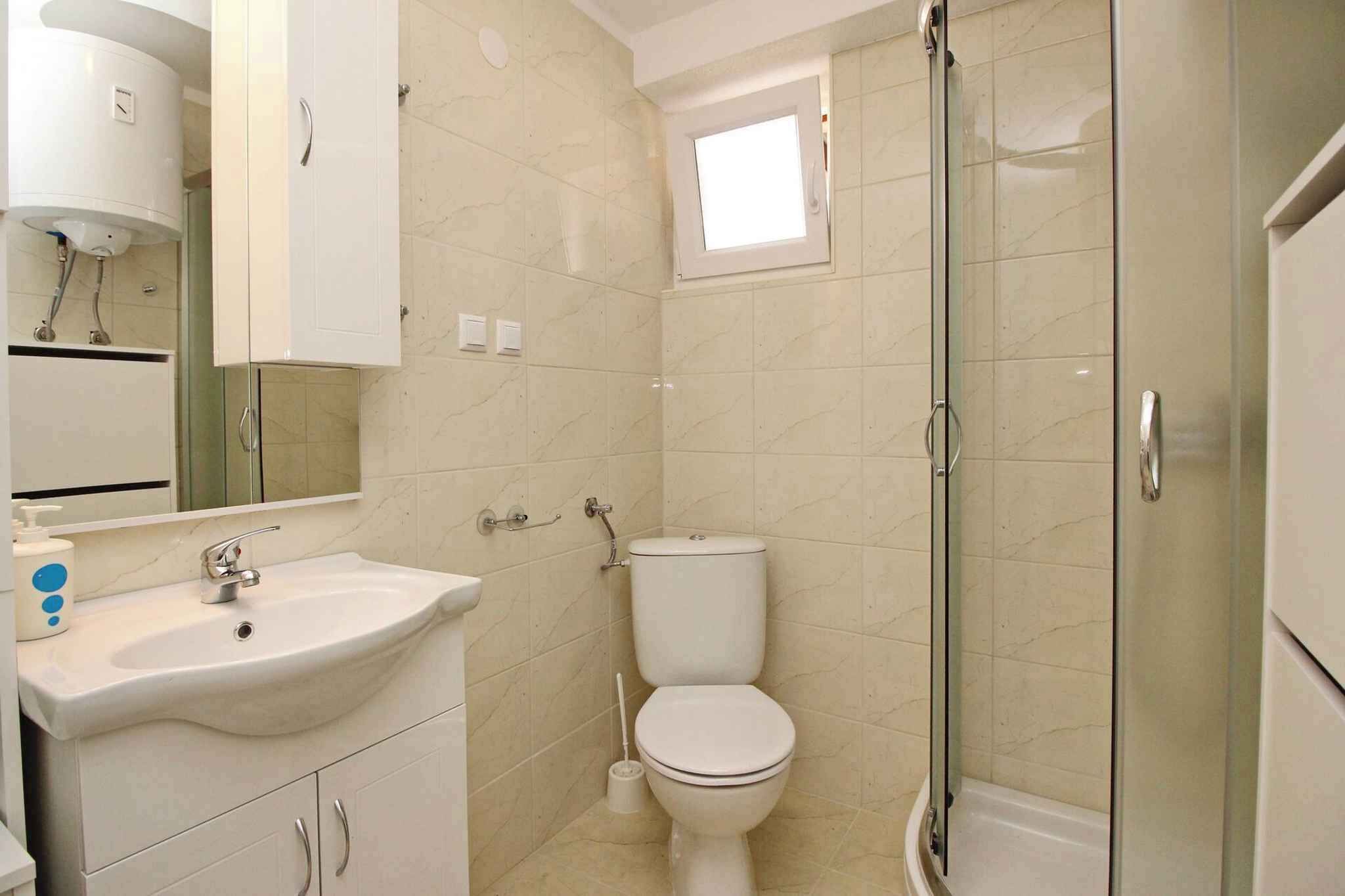 A bathroom with a sink, toilet, and glass-enclosed shower.