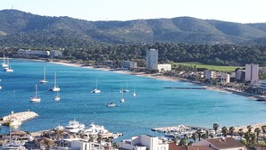 A coastal town with a marina, boats, and buildings along the shore.