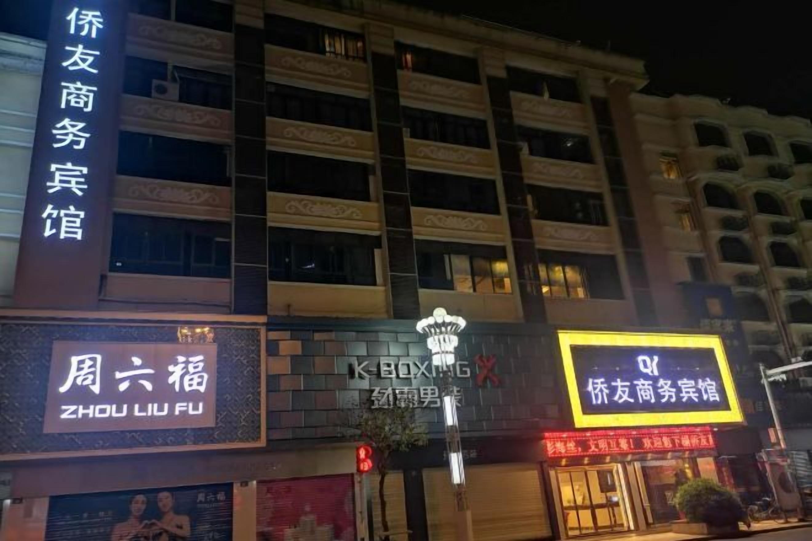 Un hotel con varios pisos y balcones, con señalización para un centro de negocios y un restaurante.