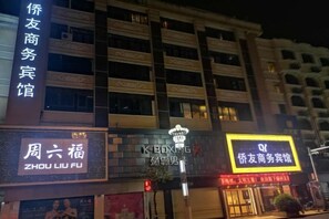 Ein Hotel mit mehreren Etagen und Balkonen, mit Schildern für ein Geschäftszentrum und ein Restaurant.