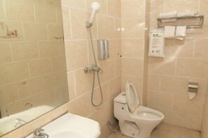 A bathroom with a toilet, a shower, a sink, and a mirror. - Quanzhou Yongchun Qiaoyou Business Hotel (Yongchun)