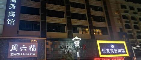 Un edificio de varios pisos con señalización que indica 'Zhou Liu Fu' y 'K-Boxing'.
