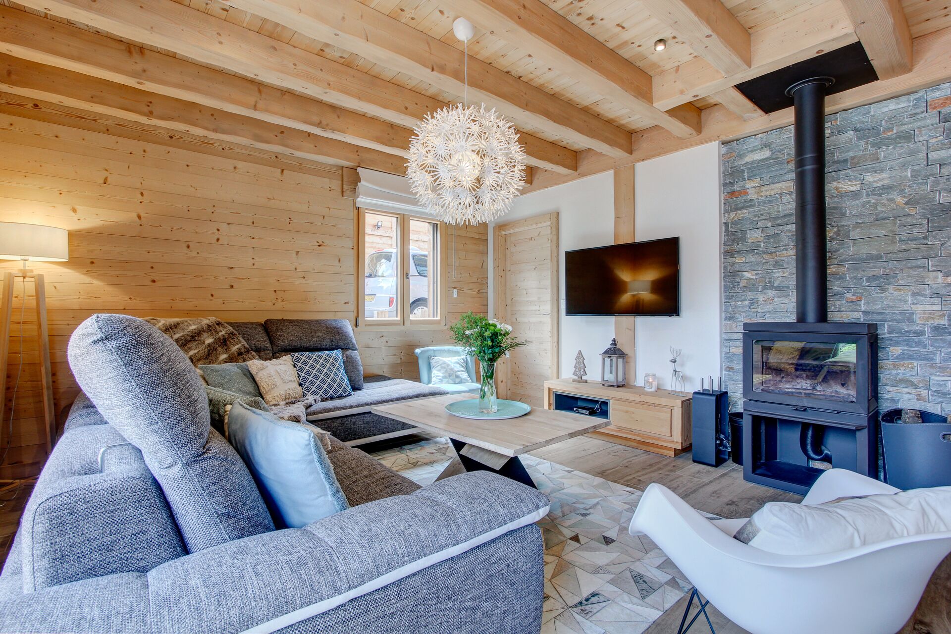 Ein gemütliches Wohnzimmer mit Sofa, Sessel und Kamin.