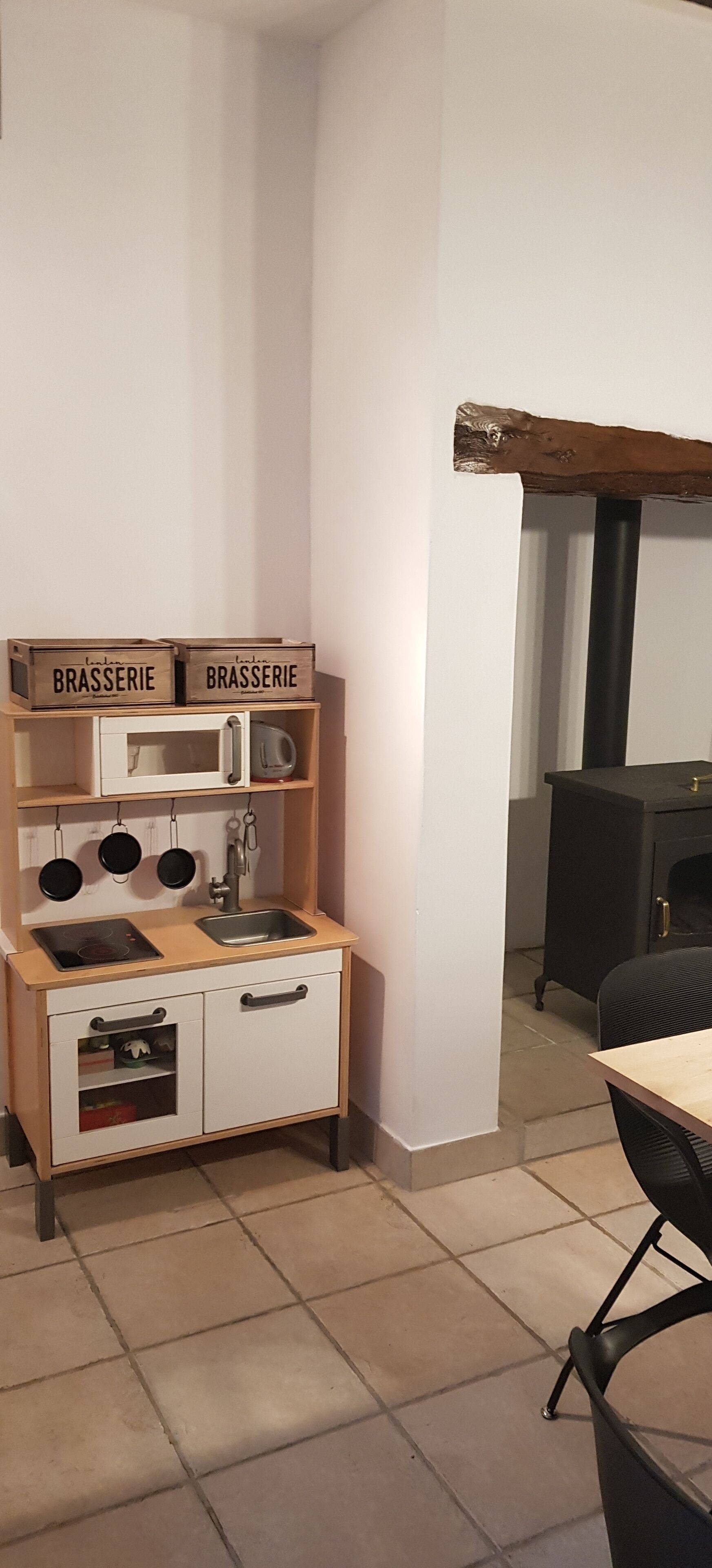 Une cuisine avec un plan de travail en bois, un évier et des placards. On peut voir deux boîtes étiquetées « BRASSERIE » sur le plan de travail.