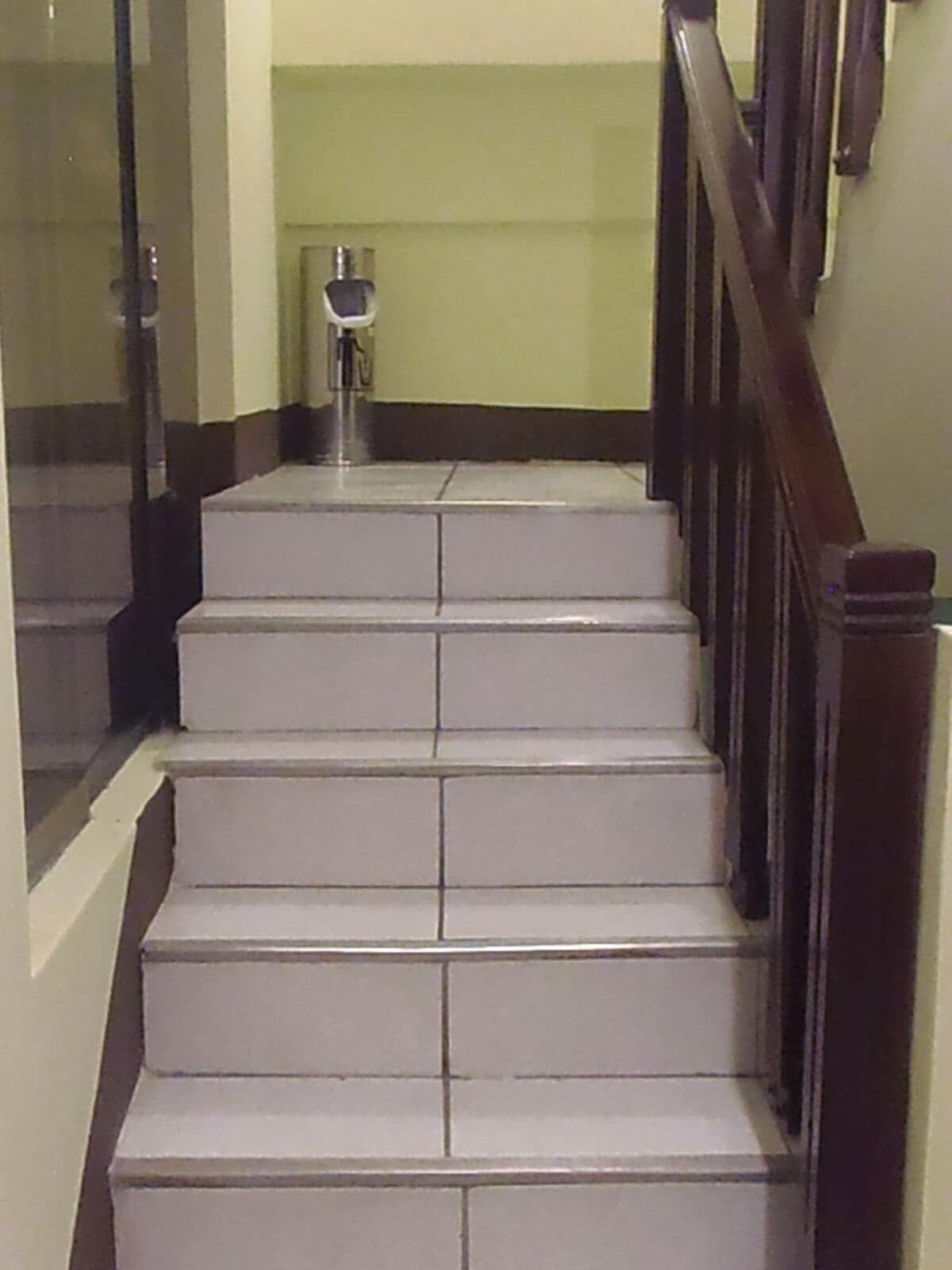 Eine Treppe mit weißen Stufen und einem Holnlauf.