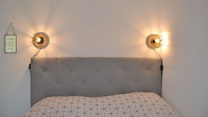 A bed with a tufted headboard and a geometric patterned pillow.