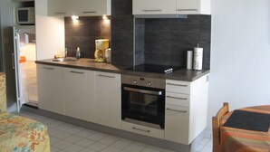 A compact kitchen with white cabinets, a microwave, a coffee maker, and a toaster. - Apartment with garden in quiet residence near beaches wi fi parking (Quiberon)
