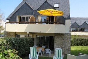 A two-story house with a balcony, a yellow umbrella, and outdoor seating. - Apartment with terrace Ideally Located In Quiet Residence wi-fi near beach (Quiberon)