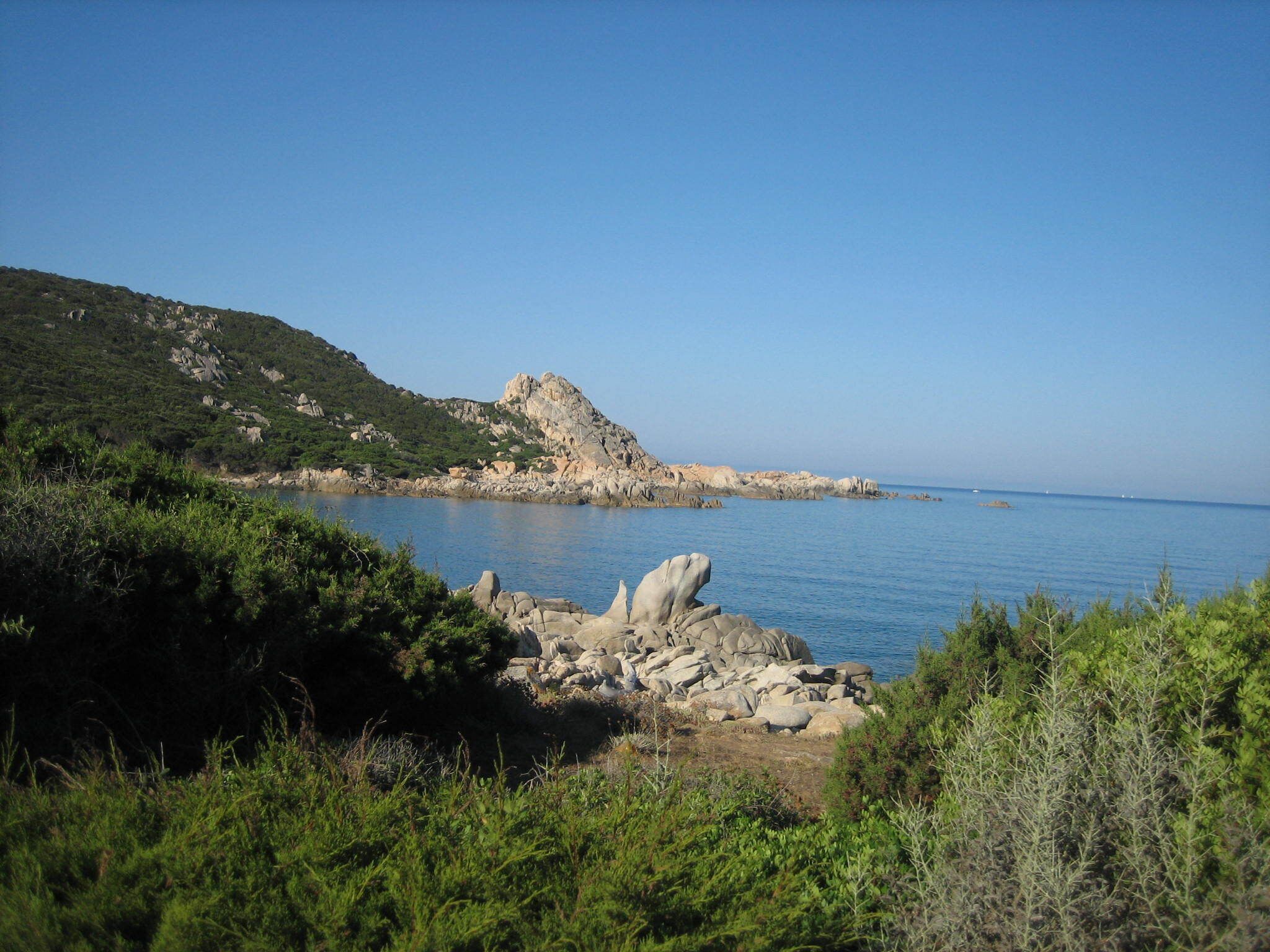 Un paysage côtier caractérisé par un terrain rocheux et une végétation luxuriante.