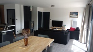 Relax in a spacious living area with a large sofa, dining table, and flat-screen TV.