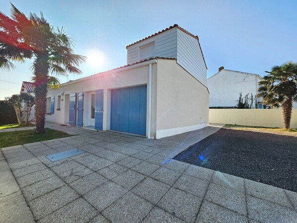 A modern building with a flat roof, a garage, and a paved driveway.