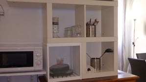 A kitchen with white cabinets, a wooden cabinet, and a microwave. - studio in quiet and sunny property near the sea. (monticello)
