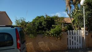 A white car parked in front of a house with a white picket fence and a street lamp. - studio in quiet and sunny property near the sea. (monticello)