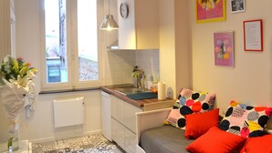 Una cocina compacta con ventana, una lámpara colgante y un pequeño comedor.