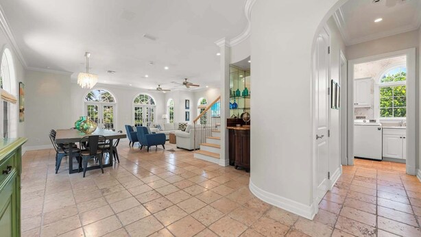 Un interior amplio con comedor, cocina y una escalera que lleva a un nivel superior.
