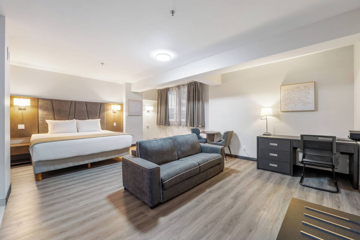 Een hotelkamer met een bed, een bank, een bureau en een stoel.