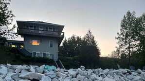 A large pile of rocks in front of a house with a balcony.