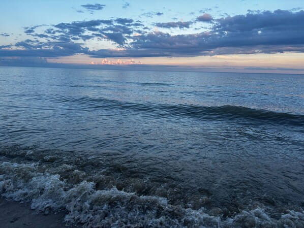 A beach with waves and a cloudy sky.