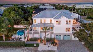 A two-story house with a pool, multiple decks, and a view of the ocean. - Sunrise Manor,  Putting Green, Pool/hot tub, Elevator, Ocean Views (Isle of Palms)