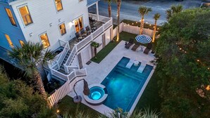 A two-story house with a swimming pool, deck chairs, and a hot tub. - Sunrise Manor,  Putting Green, Pool/hot tub, Elevator, Ocean Views (Isle of Palms)