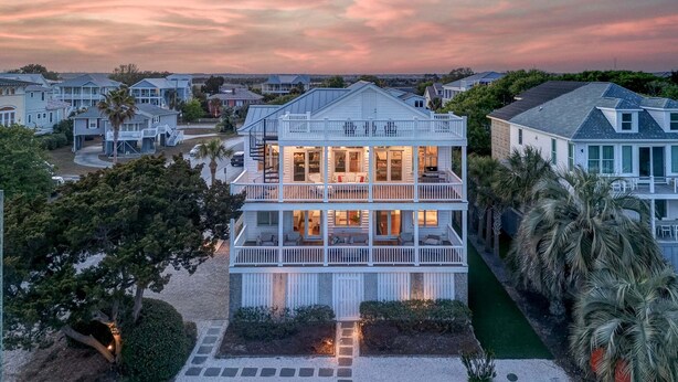 A multi-story beachfront house with a balcony, a driveway, and a well-maintained lawn. - Sunrise Manor,  Putting Green, Pool/hot tub, Elevator, Ocean Views (Isle of Palms)