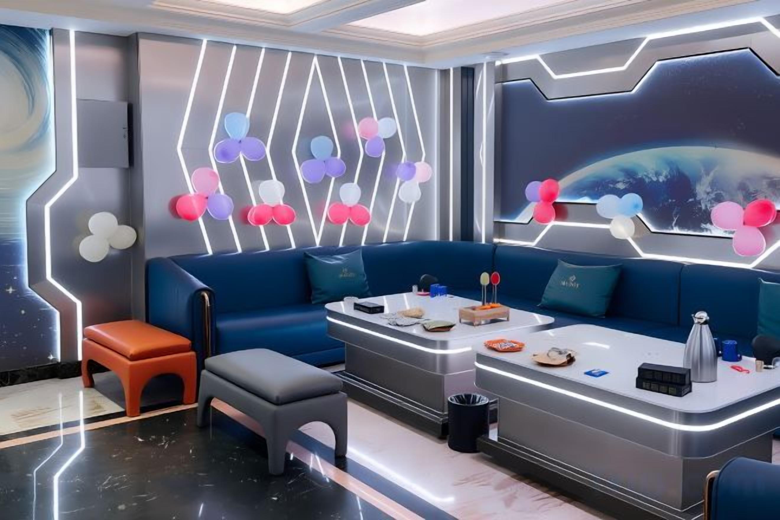 Une pièce moderne avec un canapé bleu, un petit tabouret orange, un banc gris et un comptoir sur lequel sont disposés divers objets.