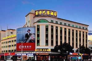 Un hôtel reconnaissable à son enseigne bien visible, à ses nombreux étages et à son grand panneau publicitaire.