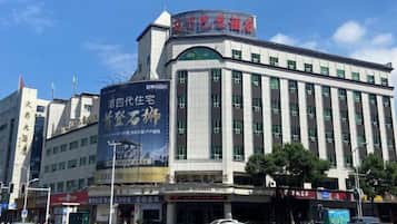 A hotel with a large signboard, multiple floors, and a prominent entrance.