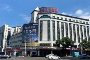 A hotel with a large signboard, multiple floors, and a prominent entrance. - Oriental Paris Business Hotel (Shishi)