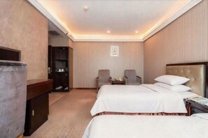 A hotel room with two beds, a desk, a wardrobe, and two armchairs. - Oriental Paris Business Hotel (Shishi)