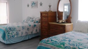 A bedroom with two beds, a ceiling fan, a dresser, and a mirror. - WATERFRONT COTTAGE w/ACCESS TO WEEKI WACHEE RIVER & GULF FRESHLY REMODELED! (Weeki Wachee)