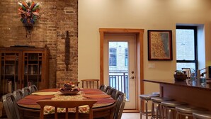 Un área de comedor con pared de ladrillo, un mueble de madera y una mesa de comedor con sillas.
