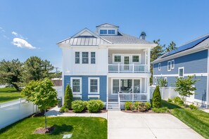 A two-story house with a front porch, a garage, and a small garden.
