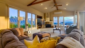 A spacious living room with a large sectional sofa, a fireplace, and a television. - Experience coastal charm near Moonlight State Beach (Encinitas)