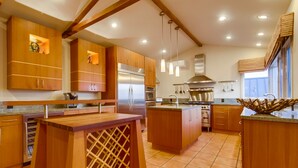 A modern kitchen with wooden cabinets, stainless steel appliances, and a central island. - Experience coastal charm near Moonlight State Beach (Encinitas)