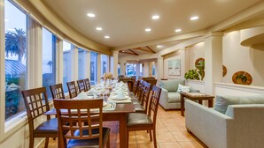 A dining area with a long table set for a meal, surrounded by chairs. - Experience coastal charm near Moonlight State Beach (Encinitas)