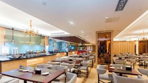 A modern restaurant with multiple dining areas, a bar, and a visible kitchen area. - Longtan Hotel (Wuxue)