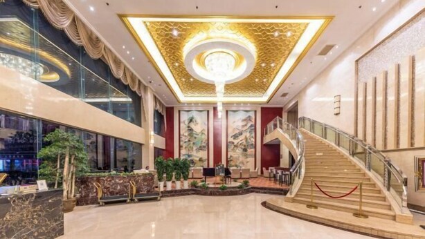 A spacious lobby with a grand staircase, a reception desk, and a large chandelier. - Longtan Hotel (Wuxue)