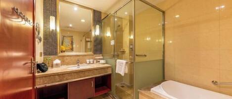 A bathroom with a glass shower enclosure, a bathtub, and a vanity with a mirror.