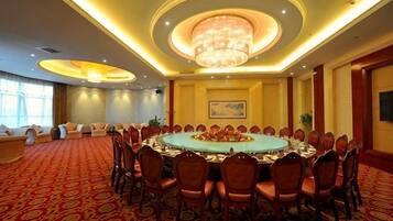 A conference room with a round table, chairs, and a chandelier.