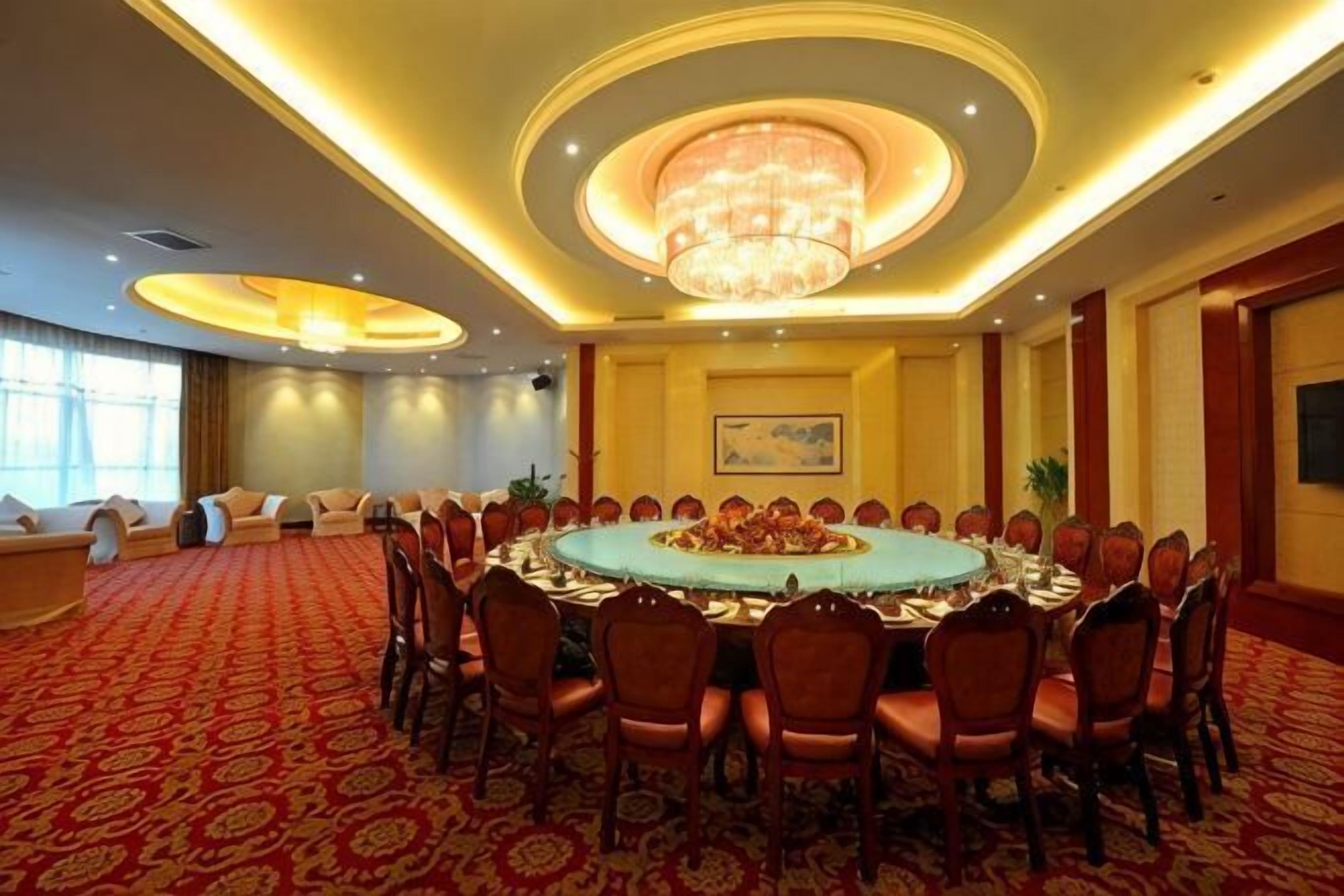 Une salle de conférence équipée d’une table ronde, de chaises et d’un lustre.