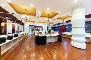 A modern hotel lobby with wooden flooring, a central island with a sink, and a unique white column structure.