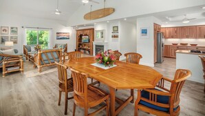 Amplia sala de estar con una gran mesa de comedor de madera, asientos cómodos y una chimenea.