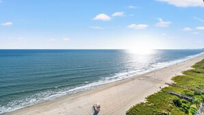 A beach with a clear view of the ocean and a distant city skyline. - Clean Bright Oceanfront Condo, Jacuzzi Tub, Pools | Crescent Shores - N 1403 (North Myrtle Beach)