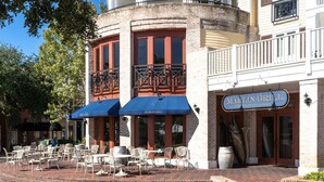 A restaurant with outdoor seating, a blue awning, and a brick facade. - Close to Golf Course, Pool, Beach, Baytowne!  Large home (2153 Sq Ft)- Peace of Heaven at Villa Lago (Miramar Beach)