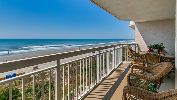 Un balcon avec vue sur la plage et l’océan.