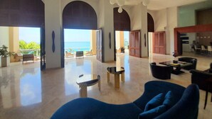 A spacious lobby with a view of the ocean, a modern seating area, and a dining space. - The CLIFF - Renovated Condo in a Luxury Beachfront Resort with Spa - Restaurant (Cupecoy)